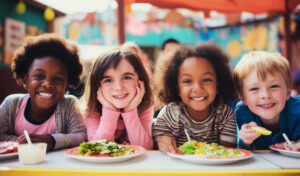 L’alimentation, moteur de l'action climatique des collectivités locales ! Happy and joyful children eating healthy food in the schoolyard. Back to school concept